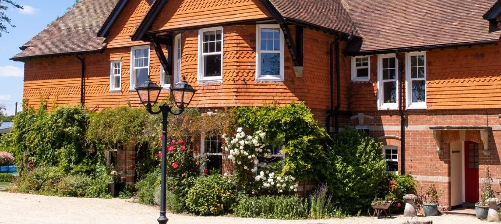 Brick and tile-hung country hotel with white sash windows