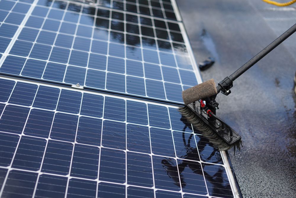 Cleaning solar panels with a brush on a pole