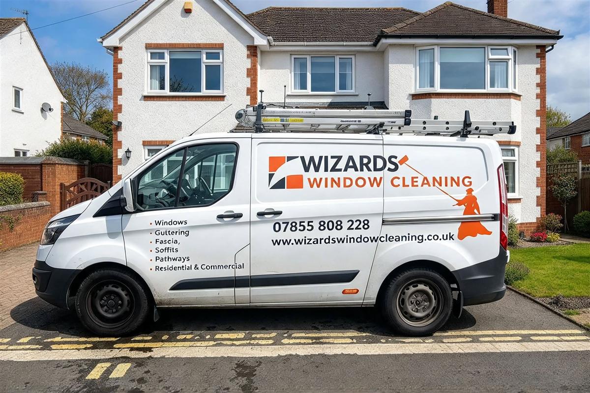 The Wizards Window Cleaning van with ladders on the roof, parked outside a house
